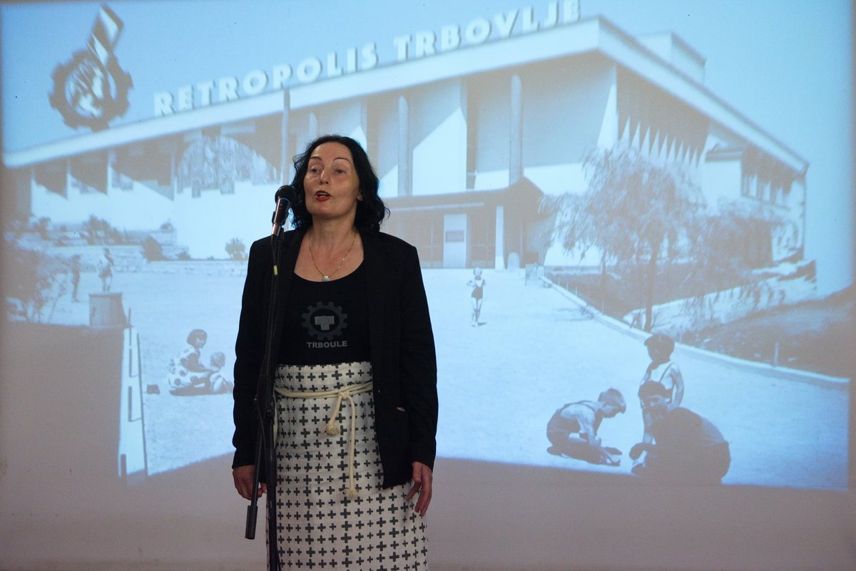 The curator of FAB3, Lili Anamarija No, on the stage, in front of an image of DDT designed by Haris Hararis.